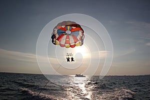 A man and a girl are flying on a parachute