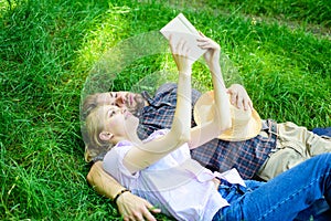 Man and girl lay on grass having fun. Couple in love spend leisure reading book. Romantic couple students enjoy leisure