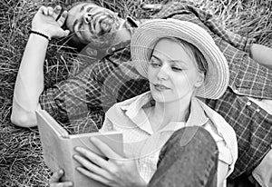 Man and girl lay on grass reading book. Couple soulmates at romantic date. Couple in love spend leisure reading book in