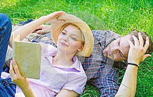Man and girl lay on grass reading book. Family enjoy leisure with poetry or literature book grass background. Couple