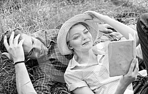 Man and girl lay on grass reading book. Family enjoy leisure with poetry or literature book grass background. Couple