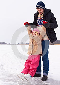 Man with girl outdoor, learn to ice skate and fun in nature with snow, sports and recreation. Father spending quality