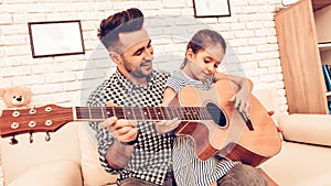 Man and Girl Play Guitar. Play Guitar. Play Piano Together. Piano and Guitar. Father and Daughter on Sofa. Spend Time Together.