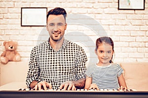 Man and Girl Play Piano. Playing Piano Together. Piano and Guitar. Father and Daughter on Sofa. Spend Time Together. Father`s day