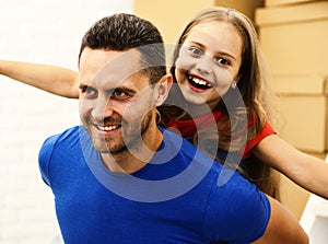 Man and girl pretend to fly on white brick background