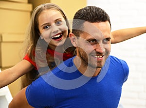 Man and girl pretend to fly on white brick background