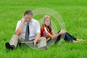 Man and girl sitting in the grass