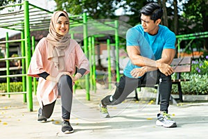 a man and a girl in a veil in gym clothes doing lunges movements