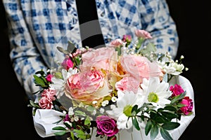 Man gives flowers. Gift box with flowers. Close up of box with pink roses in male hands. Male give gift for mother& x27;s day