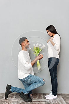 Man gives a flowers and wedding ring to woman.