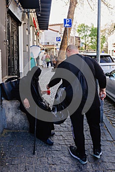 Man gives money to homeless woman at streeet photo