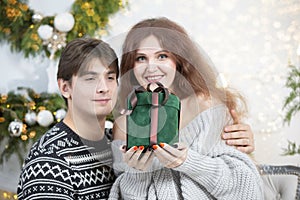 A man gives a woman a Christmas present