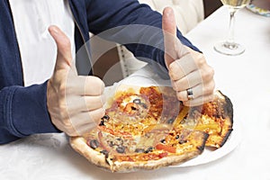 Man giving a baked homemade pizza a thumbs up