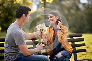 Man giving bouquet of flowers to a woman; Happy couple concept