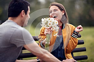 Man giving bouquet of flowers to a woman; Happy couple concept