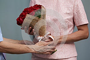 A man giving a bouquet of roses to a woman