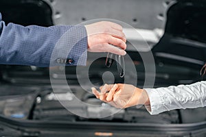 Man giving client keys to her repaired car in auto repair service