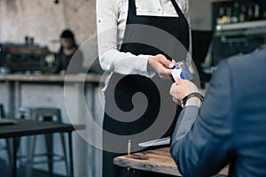 Man giving credit card to waiter in cafe