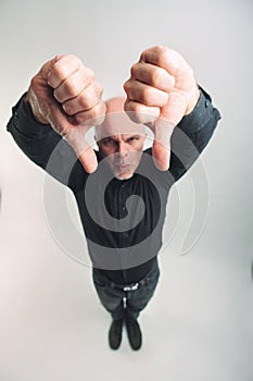 Man giving an emphatic double thumbs down showing disagreement photo