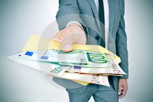 Man giving an envelope full of euro bills