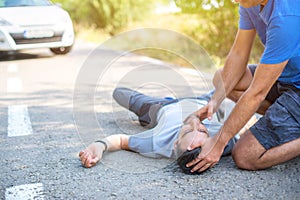 Man giving first aid in car accident