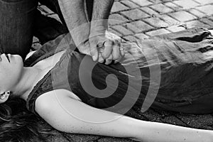 Man giving first aid to a woman during an street accident