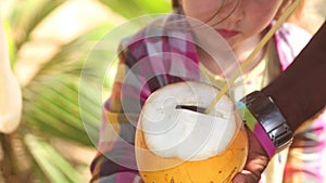 Man giving fresh coconut drink to a little girl