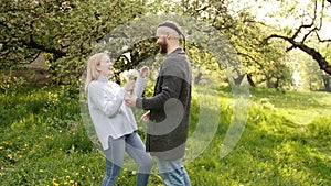 The man is giving his girlfriend a bunch of dandelions