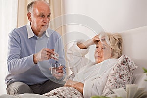 Man giving his sick wife pills