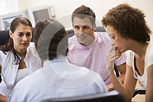 Man giving lecture to three people