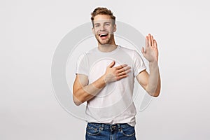 Man giving oath, swear telling truth or be honest. Happy confident and charismatic blond handsome man in white t-shirt