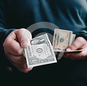 Man giving one us dollar banknote and holding cash in hands.Money credit concept