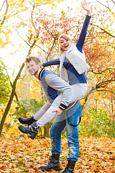 Man giving piggyback ride to woman in park