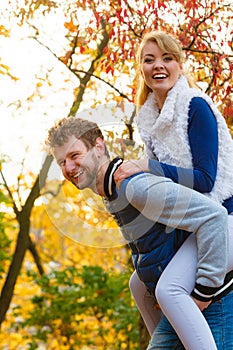 Man giving piggyback ride to woman in park