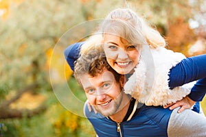 Man giving piggyback ride to woman in park