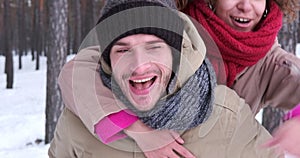 Man giving piggyback ride to woman in winter