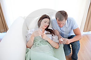 Man giving pills to his sick wife