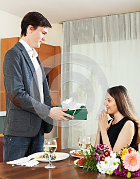 Man giving present to woman during romantic dinner