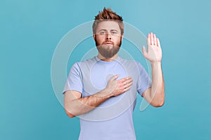 Man giving promise with hand on heart, pledging allegiance, giving vow with responsible serious face