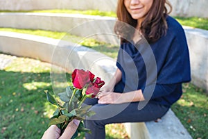 A man giving red rose flowers to beautiful girlfriend on Valentine`s day