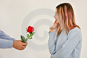 Man giving a red rose and surprised woman. Valentine card concept.