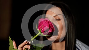 man is giving red rose to beloved woman, happy brunette lady is taking flower and smiling