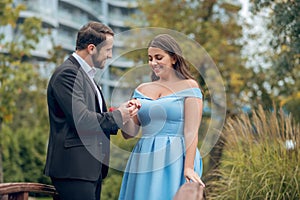 Man giving ring to lovely woman outdoors.