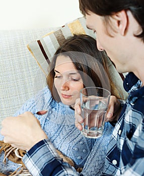 Man giving sirup to unwell woman