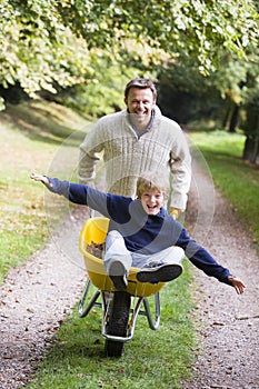 Man giving son ride in wheelbarrow