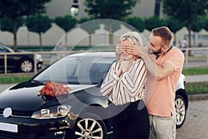 Man giving surprise to woman by purchasing a new car. Surprise gift for a loved one