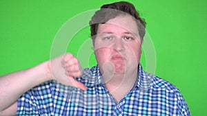 Man Giving Thumbs Down Sign signifying rejection, refusal, or disapproval on Green Screen.