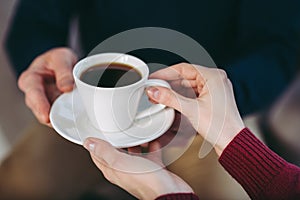 Man giving woman cup of coffee