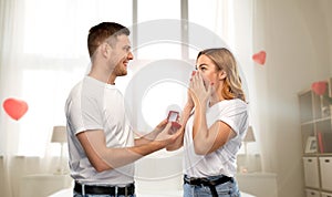 Man giving woman engagement ring on valentines day