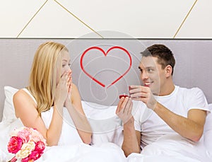 Man giving woman little red box and ring in it